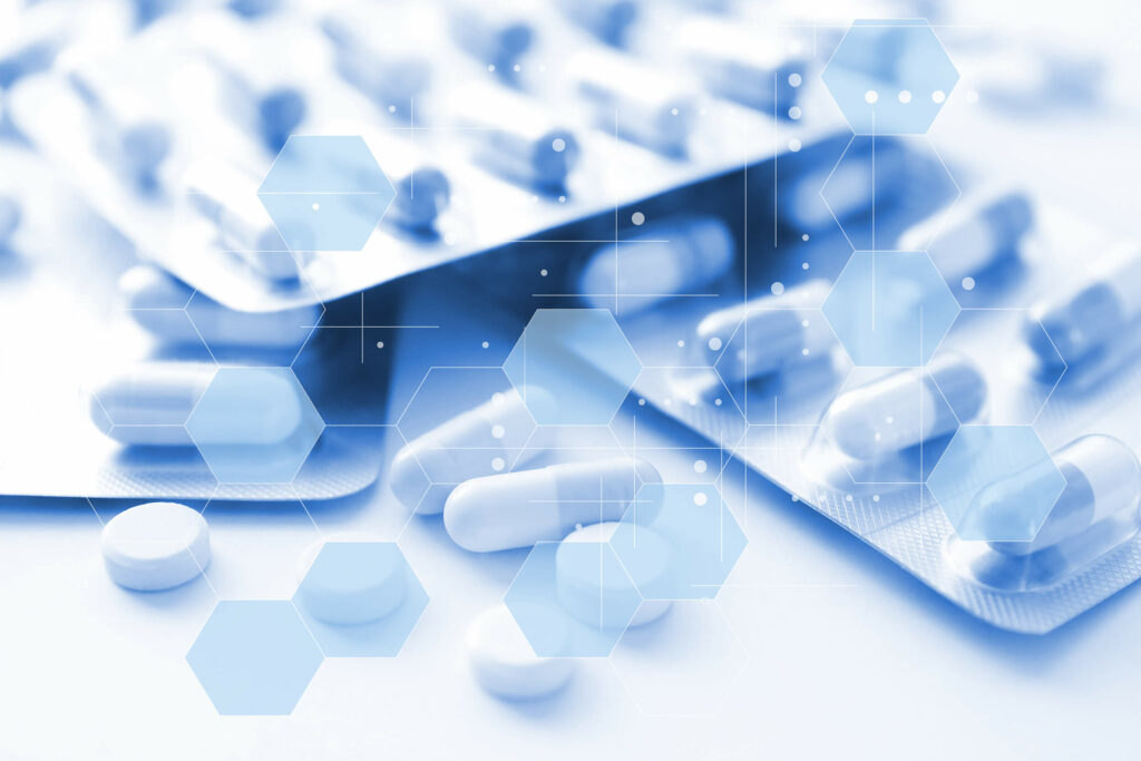 Tiefenbacher Group - Blister packs of white pills and capsules are arranged on a white surface, overlaid with translucent blue hexagons and digital interface elements, reflecting patient-centric drug development by a family-owned pharmaceutical company.